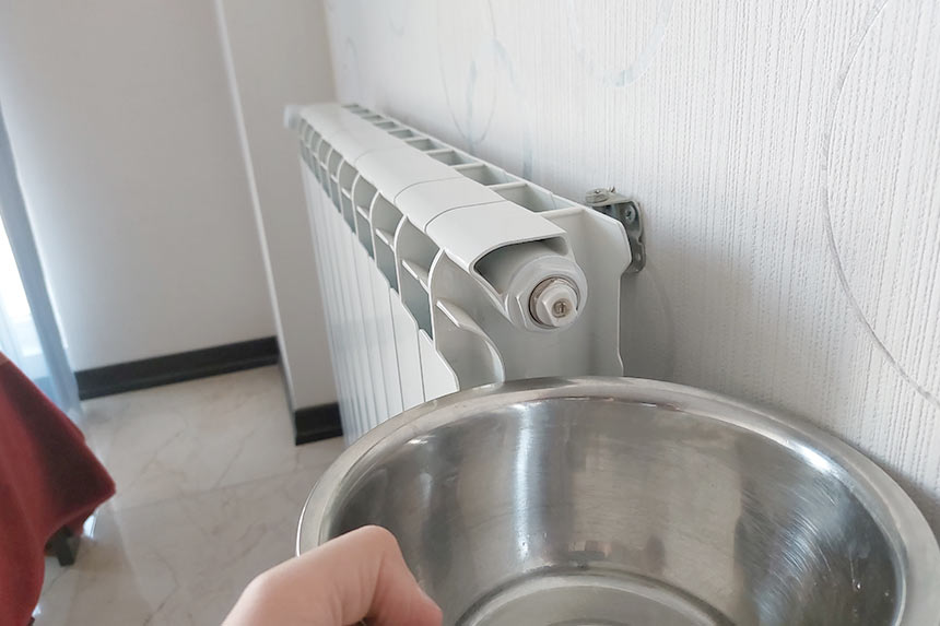 Place a container on a towel below the radiator’s bleed valve